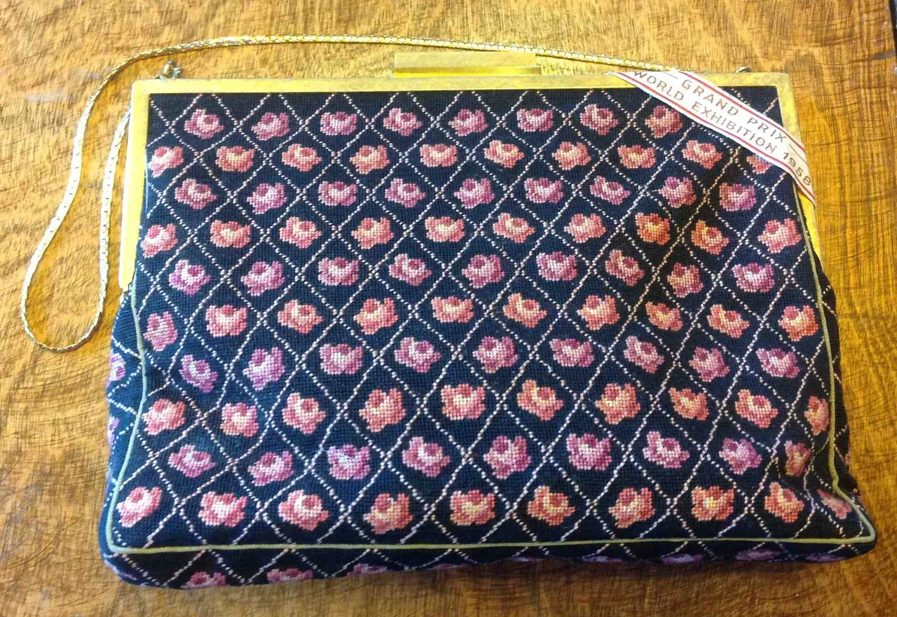 Petit-point rose purse with a ribbon reading Grand Prix World Exhibition 1958.