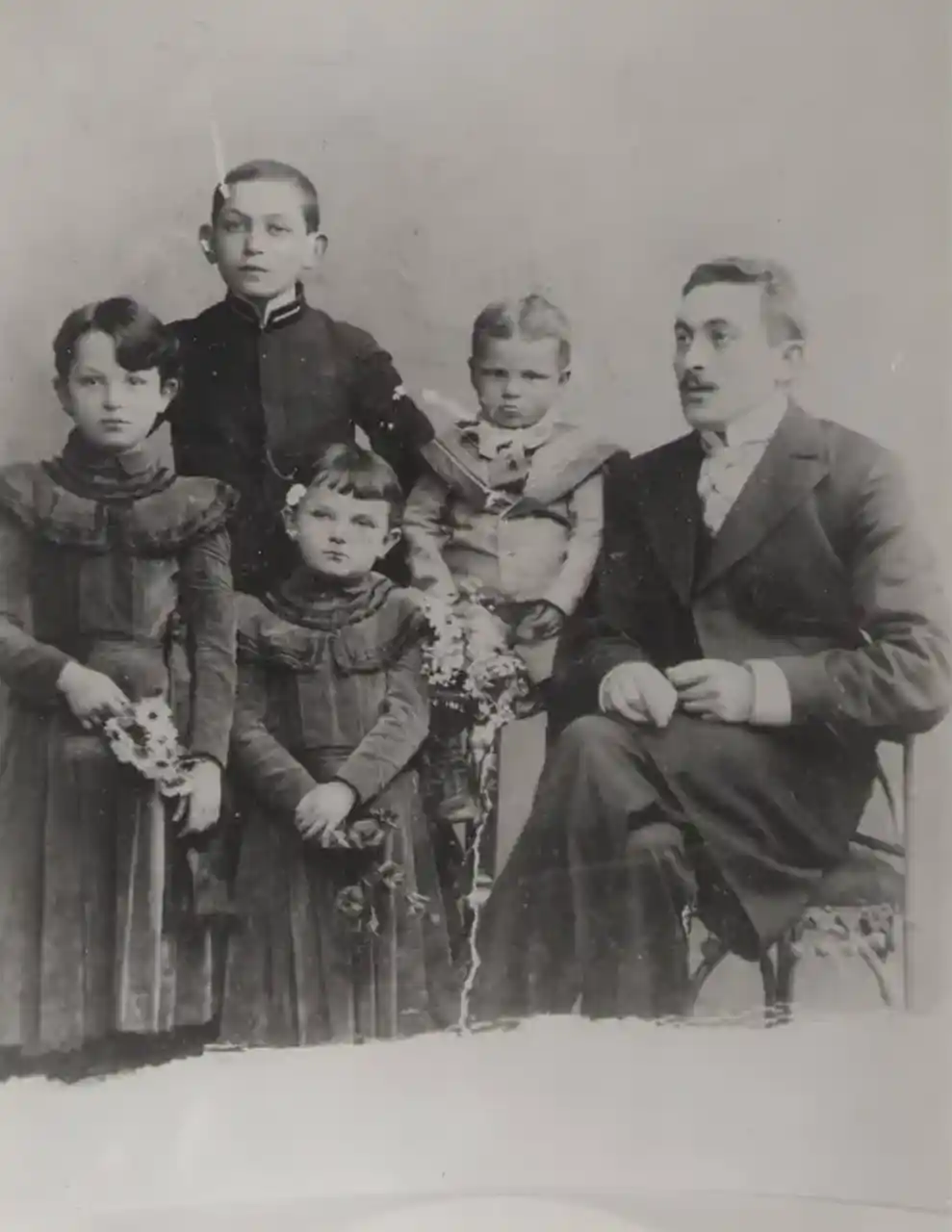 Studio photograph of a man and four children, early twentieth century.